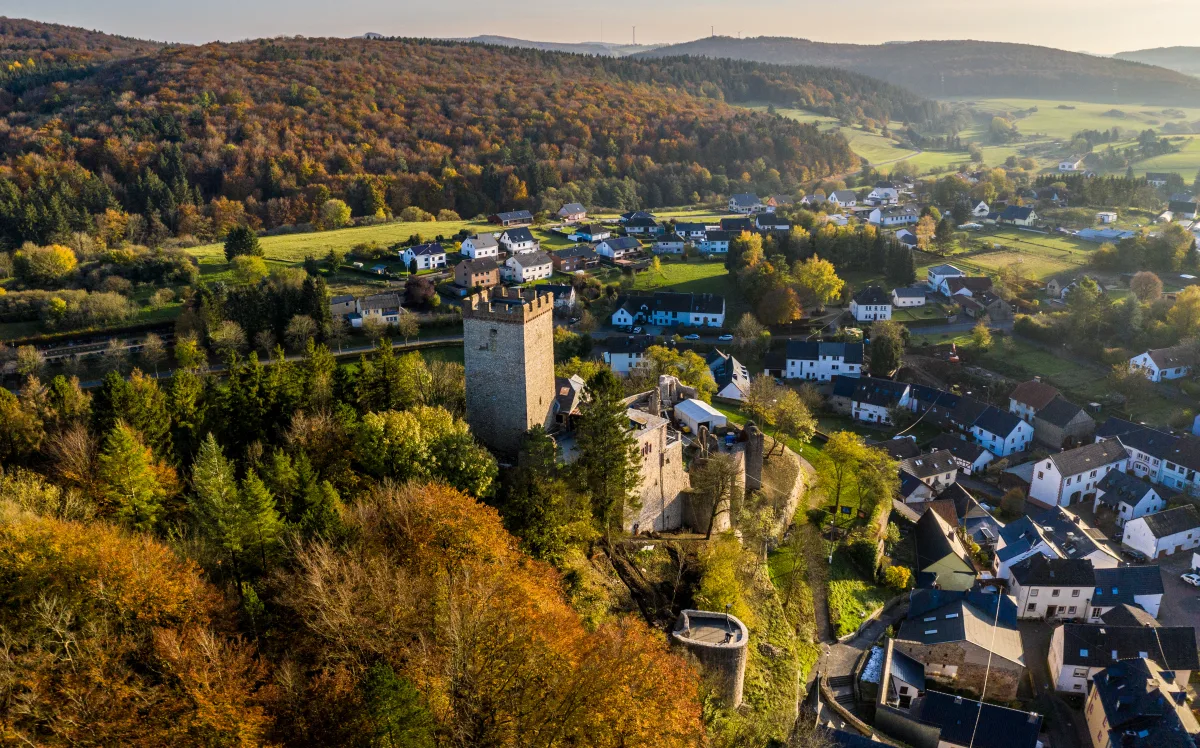 Burg Kerpen mit Bergfried und Ortschaft im herbstlichen Abendlicht
