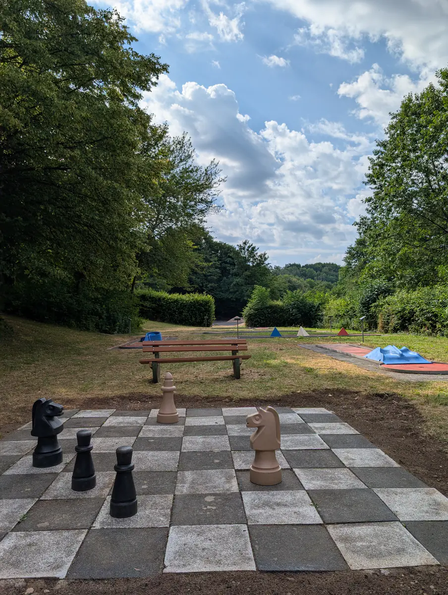 Outdoor-Schachfeld mit übergroßen Spielfiguren auf der Freizeitanlage Kerpen, Minigolfbahnen im Hintergrund